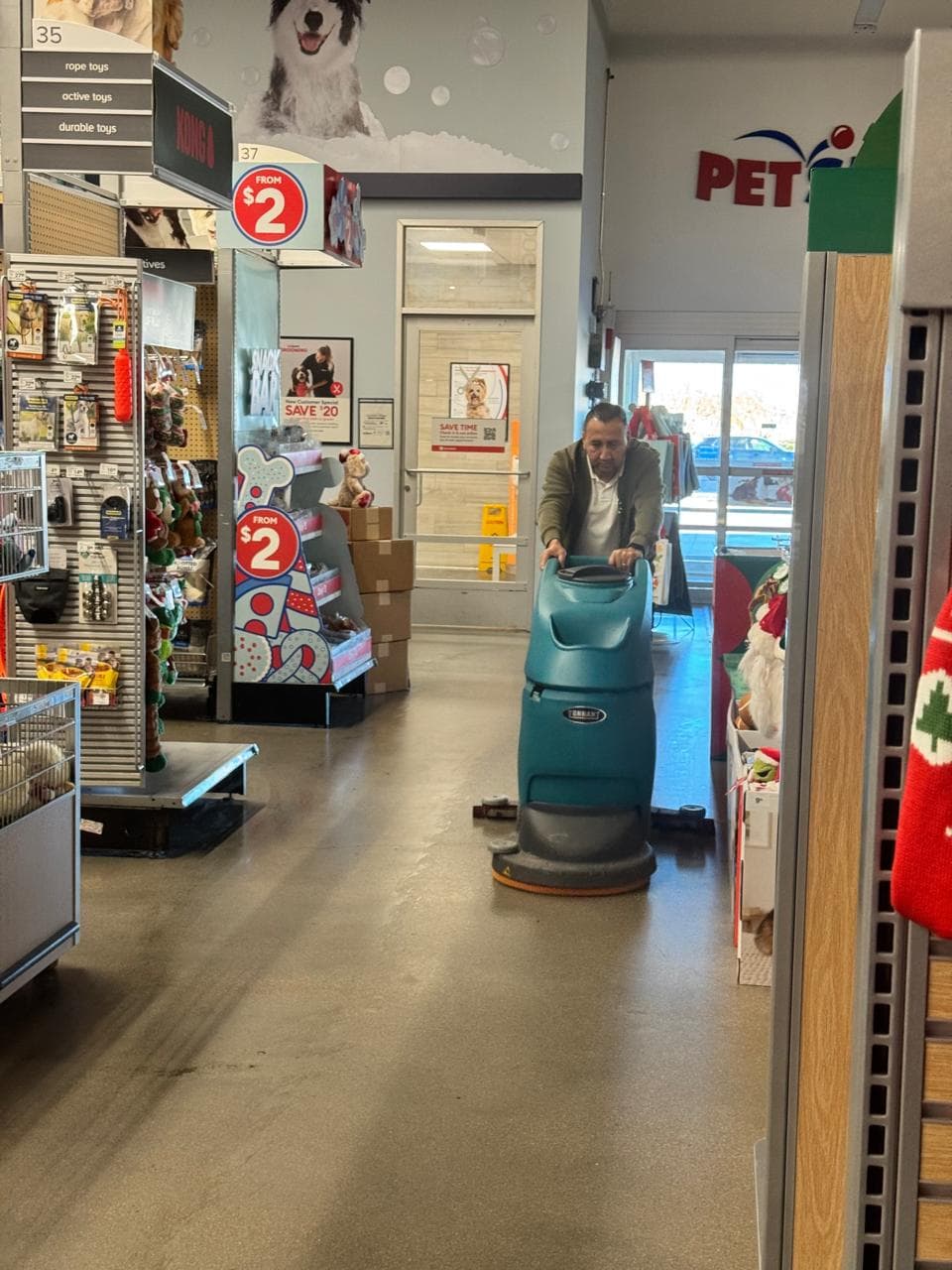 Kathy Clean technician operating a Tennant floor scrubber inside a PetSmart store in Denver